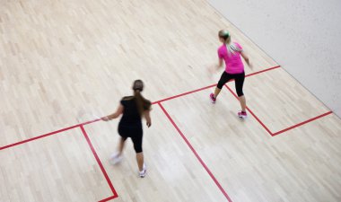 İki kadın squash oyuncular bir squash kortu (moti hızlı eylem içinde