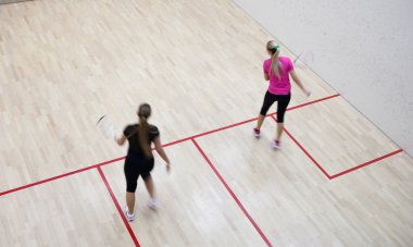 İki kadın squash oyuncular bir squash kortu (moti hızlı eylem içinde