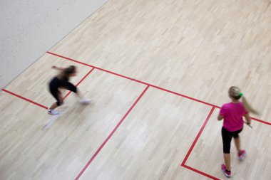 İki kadın squash oyuncular bir squash kortu (moti hızlı eylem içinde