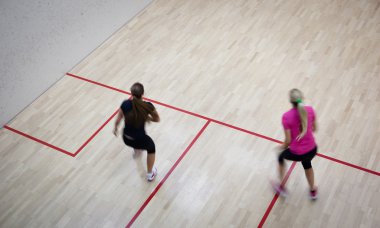 İki kadın squash oyuncular bir squash kortu (moti hızlı eylem içinde