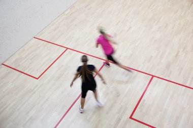 İki kadın squash oyuncular bir squash kortu (moti hızlı eylem içinde