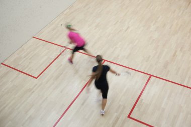 İki kadın squash oyuncular bir squash kortu (moti hızlı eylem içinde