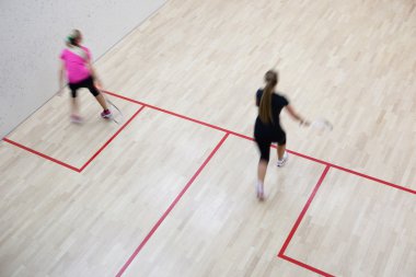 İki kadın squash oyuncular bir squash kortu (moti hızlı eylem içinde