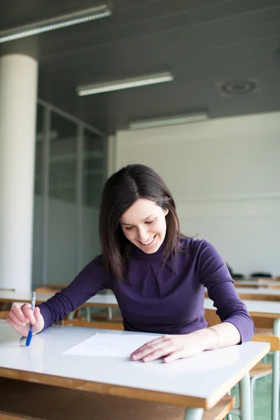 Porträt einer hübschen Studentin, die in einem Klassenzimmer arbeitet — Stockfoto