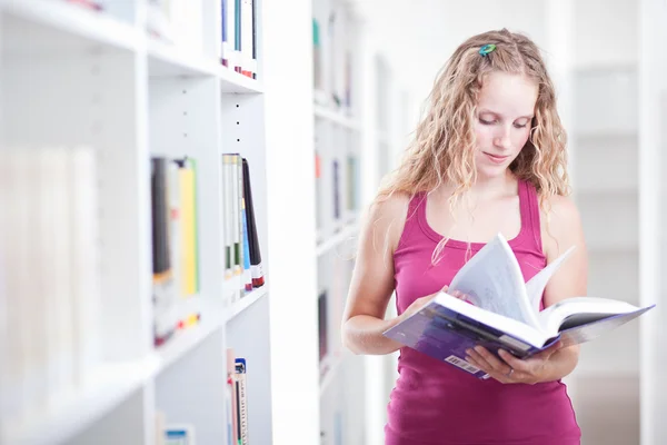 Vrij vrouwelijke college student in een bibliotheek (ondiepe Dof; kleur t — Stockfoto