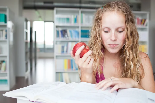 Jolie étudiante dans une bibliothèque (peu profonde DOF ; couleur t — Photo