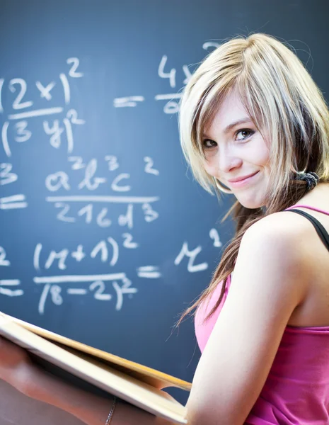 Hübsche junge Studentin, die auf der Tafel / Tafel schreibt — Stockfoto