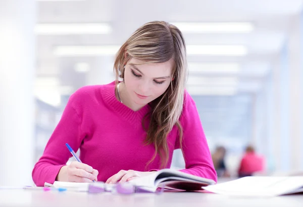In de bibliotheek - vrij vrouwelijke student met laptop en boeken wor — Stockfoto