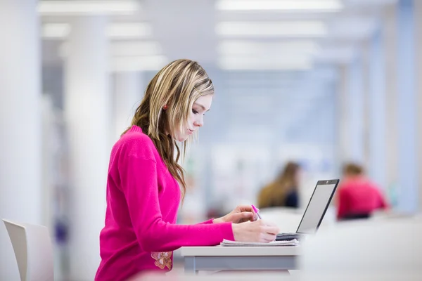 Na biblioteca - bonita, estudante do sexo feminino com laptop e livros wo — Fotografia de Stock