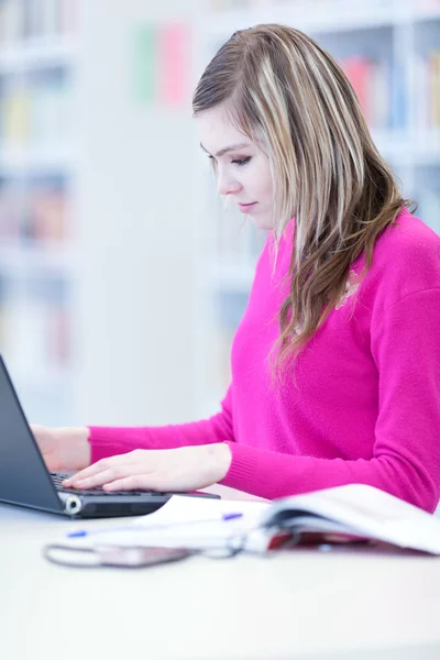 Dans la bibliothèque - jolie étudiante avec ordinateur portable et livres wor — Photo