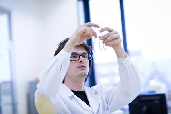Bir kimya bilimsel araştırma yürüten genç erkek araştırmacı — Stok fotoğraf