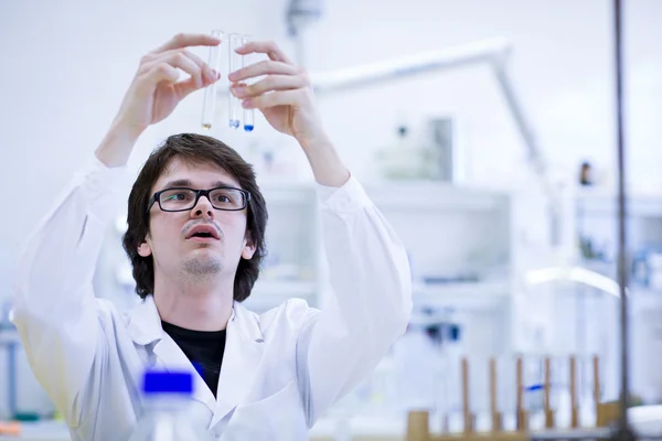 Молодой исследователь-мужчина проводит научные исследования в области химии — стоковое фото