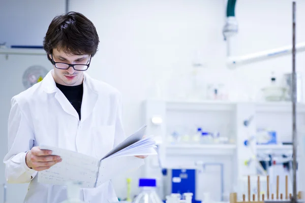 Joven investigador masculino que lleva a cabo investigación científica en una química —  Fotos de Stock