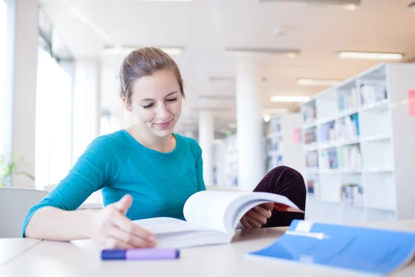 Hübsche junge Studentin in einer Bibliothek (flach dof; Farbe zu — Stockfoto
