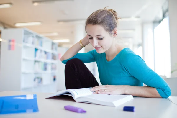 Abbastanza giovane studente universitario in una biblioteca (DOF superficiale; colore a — Foto Stock