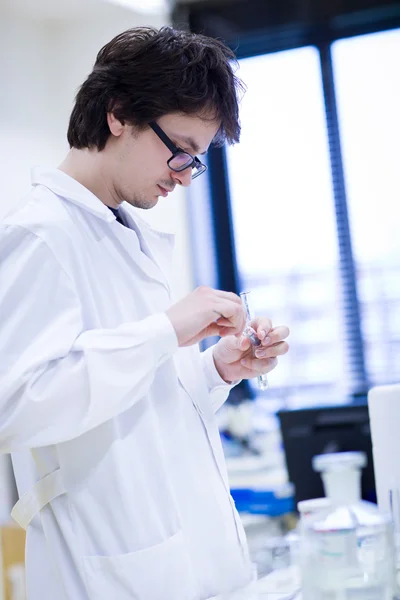 Молодой исследователь-мужчина проводит научные исследования в области химии — стоковое фото