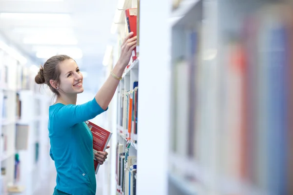 Hezká mladá studentka v knihovně (mělké Dof, barva — Stock fotografie