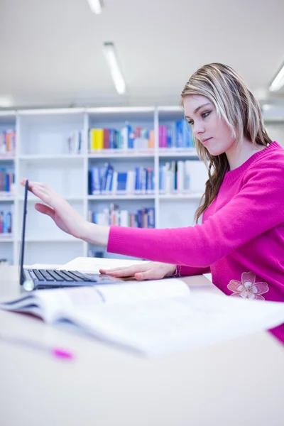 Στη βιβλιοθήκη - όμορφη, θηλυκό φοιτητής με laptop και βιβλία wo — Φωτογραφία Αρχείου