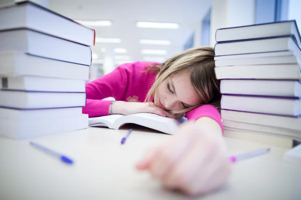 In the library - very tired/exhausted, pretty, female student wi — Stock Photo, Image