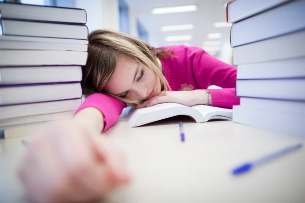 In de bibliotheek - zeer moe/uitgeput, mooie, vrouwelijke student wi — Stockfoto