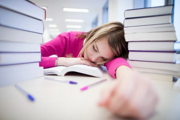 In the library - very tired/exhausted, pretty, female student wi — Stock Photo, Image