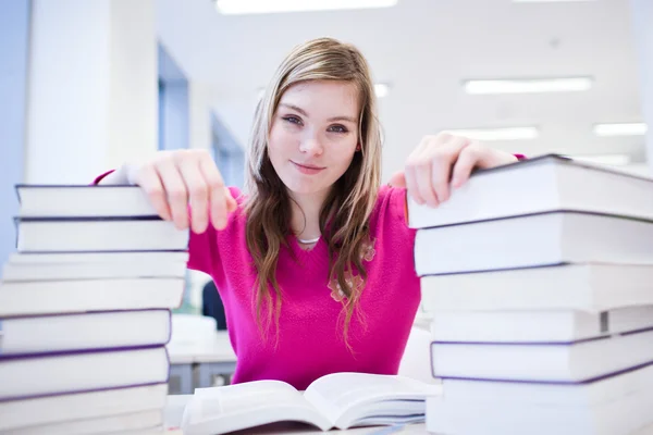 In der Bibliothek - hübsche Studentin mit Laptop und Büchern — Stockfoto