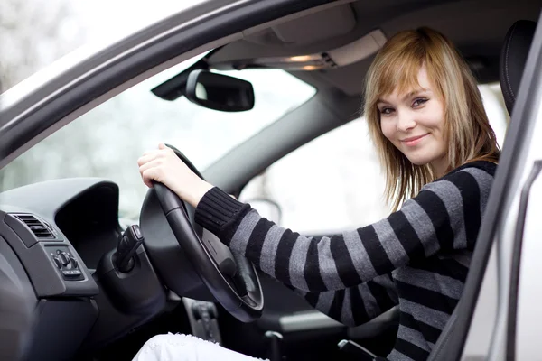 Αρκετά νεαρή γυναίκα οδήγηση αυτοκινήτου της νέα (ρηχά Dof, τονισμένο χρώμα — Φωτογραφία Αρχείου