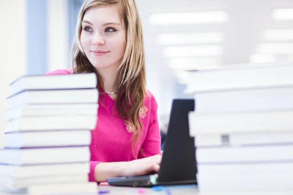In de bibliotheek - mooie, vrouwelijke student met laptop en boeken wo — Stockfoto