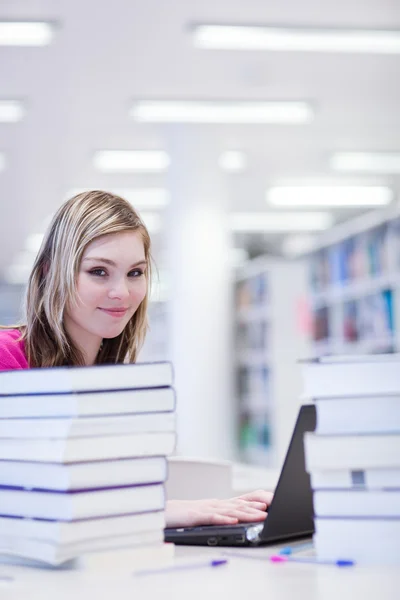 En la biblioteca - bonita, estudiante con portátil y libros wo — Foto de Stock
