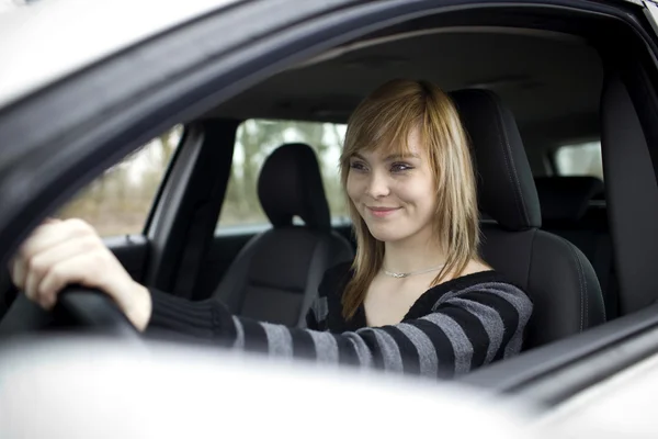 Αρκετά νεαρή γυναίκα οδήγηση αυτοκινήτου της νέα (ρηχά Dof, τονισμένο χρώμα — Φωτογραφία Αρχείου