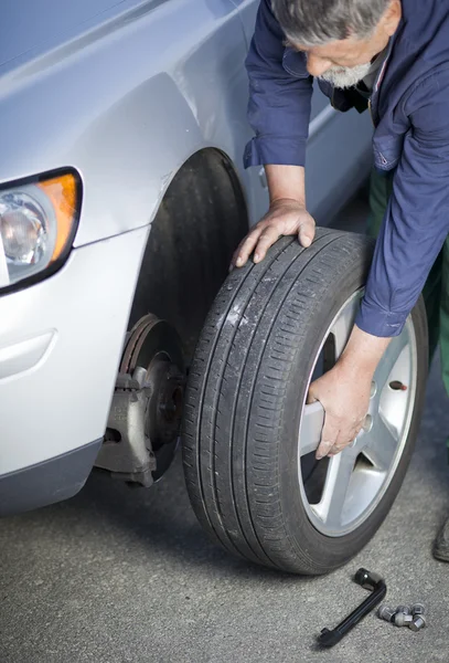 Mechanic een wiel van een moderne auto (ondiepe Dof; kleur te wijzigen — Stockfoto