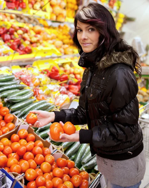 Güzel bir genç kadın satın alma meyve ve sebzeler bir üretmek — Stok fotoğraf