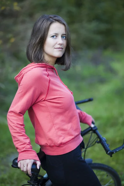 Hezká mladá žena motorkář outddors na horském kole (mělká — Stock fotografie