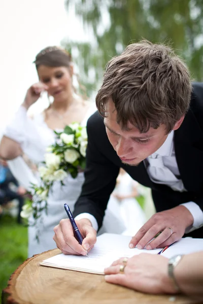 Casal de casamento jovem - noivo recém-casado e noiva posando outdoo — Fotografia de Stock