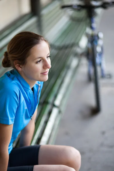 Retrato de una hermosa motociclista al aire libre descansando en un banco (s) — Foto de Stock