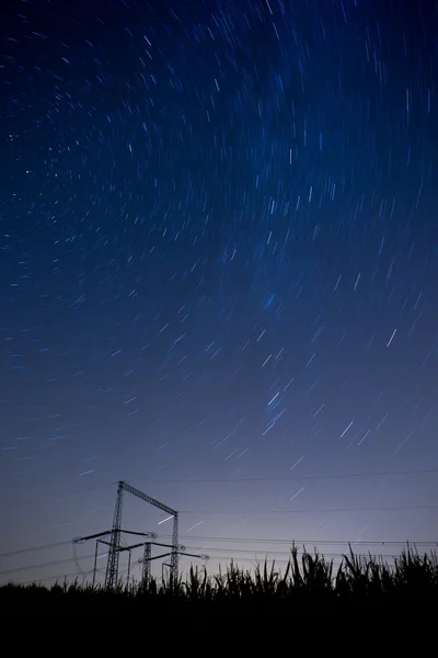 Зоряний нічний пейзаж з високовольтними полюсами — стокове фото