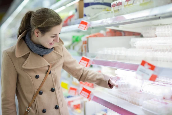 Pretty young woman buying groceries in a supermarket/mall/grocer — Stock Photo, Image