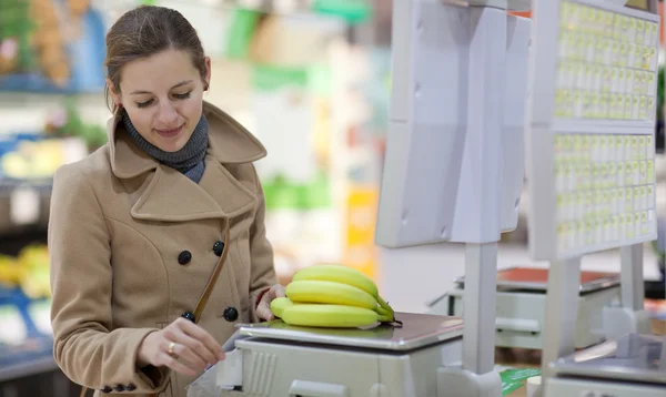 Mooie jonge vrouw winkelen voor groenten en fruit in prod — Stockfoto