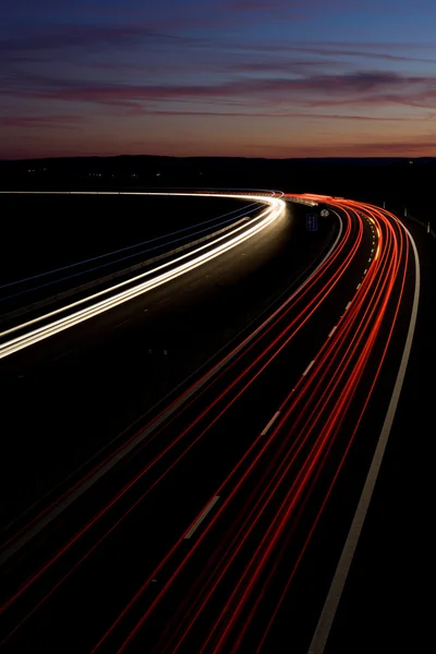 Автомобили быстро движутся по ночному шоссе (размытое изображение движения) ) — стоковое фото