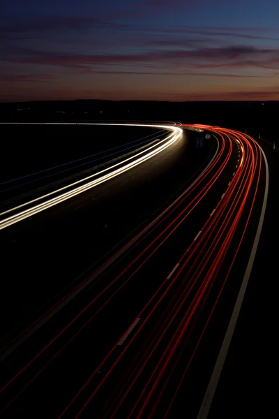 Автомобили быстро движутся по ночному шоссе (размытое изображение движения) ) — стоковое фото
