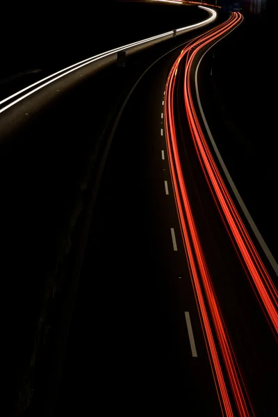 Coches que se mueven rápido en una carretera nocturna (imagen borrosa movimiento ) — Foto de Stock