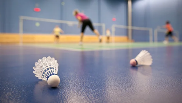 Badminton - badminton courts with players competing; shuttlecock — Stock Photo, Image