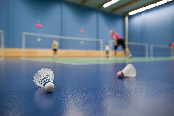 Badminton - badminton courts with players competing; shuttlecock — Stock Photo, Image