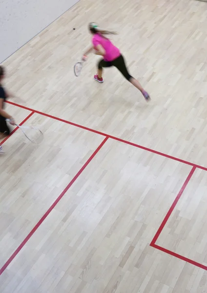 Dvě ženské squashové hráče v rychlou akci na squashovém kurtu (moti — Stock fotografie