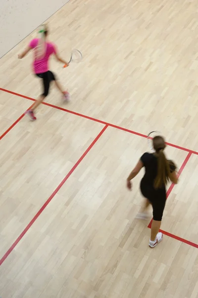 Duas jogadoras de squash feminino em ação rápida em uma quadra de squash (moti — Fotografia de Stock