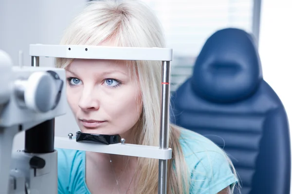 Optometria koncepcja - dość młody pacjentki o jej oczy — Zdjęcie stockowe