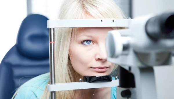 Optometri kavramı - genç ve güzel kadın gözleri muayene olması — Stok fotoğraf