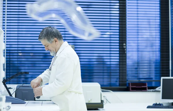 Старший исследователь-мужчина проводит научные исследования в лаборатории — стоковое фото