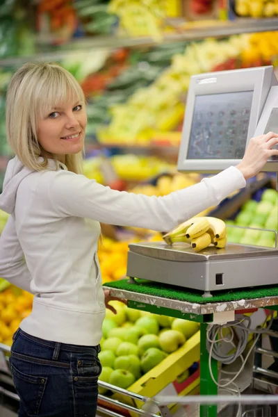 Beautiful young woman shopping for fruits and vegetables in prod — Stock Photo, Image