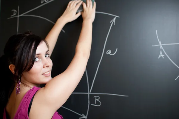 Pretty young college student drawing on the chalkboard/blackboar Stock Photo